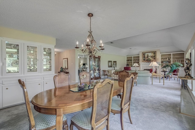 332 N Amherst Dr, West Columbia, TX 77486 - dining room featuring vaulted ceiling, a chandelier, light carpet, built in features, and a textured ceiling