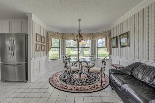 332 N Amherst Dr, West Columbia, TX 77486 - dining area with healthy amount of natural light, a textured ceiling, crown molding, wallpapered walls, and wainscoting