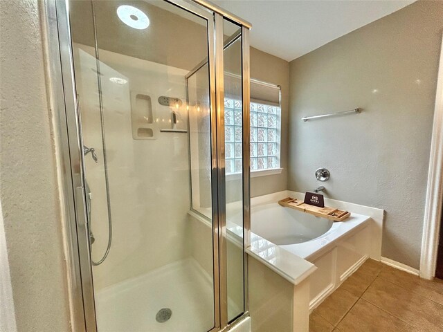 2110 Sterling Oaks Dr, Rosharon, TX 77583 - bathroom featuring a stall shower, tile patterned floors, a bath, and a textured wall