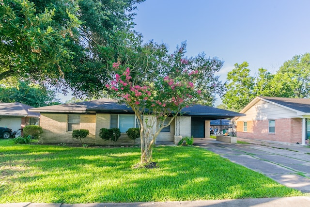6609 Imogene St, Houston, TX 77074 - view of front facade with driveway, an attached carport, brick siding, and a front yard