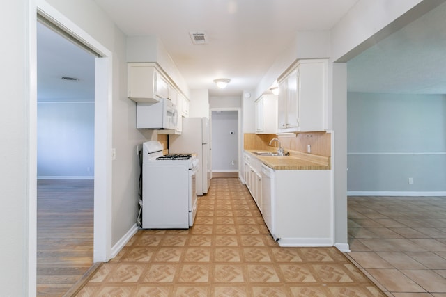 6609 Imogene St, Houston, TX 77074 - kitchen featuring white appliances, light countertops, white cabinets, backsplash, and light tile patterned floors