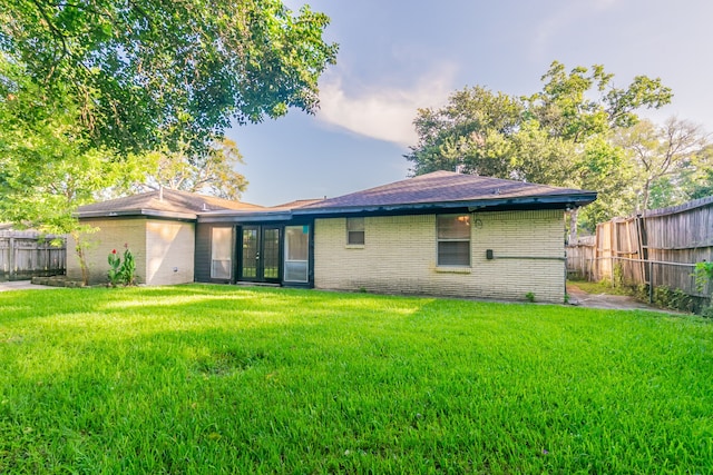 6609 Imogene St, Houston, TX 77074 - back of property with french doors, brick siding, and a fenced backyard