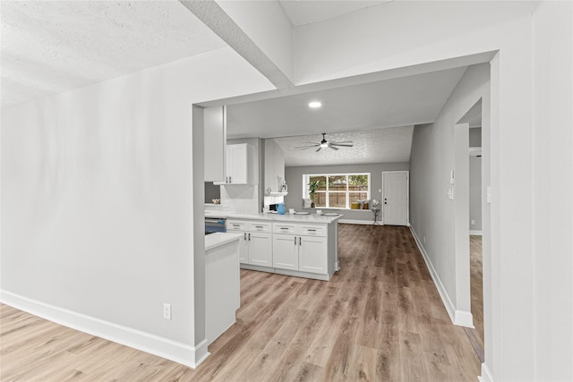 10503 Long River Dr, Sugar Land, TX 77498 - kitchen featuring light countertops, light wood-style floors, white cabinetry, a textured ceiling, and ceiling fan