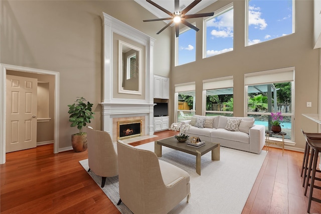 1922 Briarchester Dr, Katy, TX 77450 - living area featuring a towering ceiling, a ceiling fan, hardwood / wood-style flooring, and a tiled fireplace
