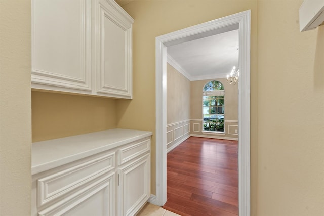 1922 Briarchester Dr, Katy, TX 77450 - hall featuring ornamental molding, light wood finished floors, a chandelier, a decorative wall, and wainscoting