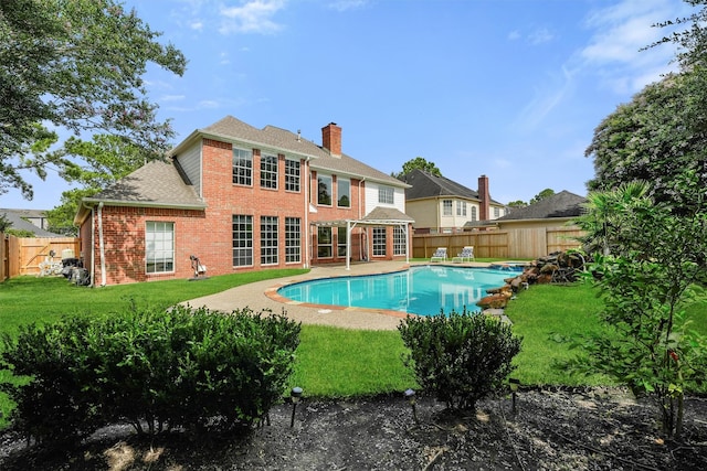 1922 Briarchester Dr, Katy, TX 77450 - back of house with brick siding, a fenced backyard, roof with shingles, a chimney, and a patio