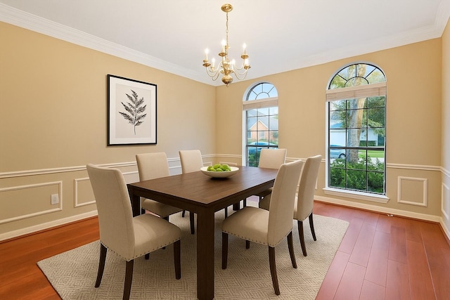1922 Briarchester Dr, Katy, TX 77450 - dining room with a chandelier, wood finished floors, a wainscoted wall, ornamental molding, and a decorative wall