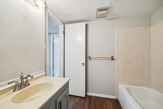 2850 Pheasant Run, Humble, TX 77396 - bathroom featuring wood finished floors, vanity, a textured wall, and a textured ceiling