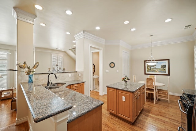 4009 Bellefontaine St, Houston, TX 77025 - kitchen with gas range oven, tasteful backsplash, light wood finished floors, ornamental molding, and brown cabinets