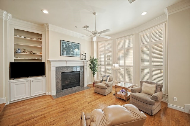 4009 Bellefontaine St, Houston, TX 77025 - living room with crown molding, light wood-style floors, a high end fireplace, a ceiling fan, and recessed lighting