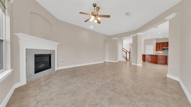 12610 Baldwin Springs Ct, Tomball, TX 77377 - unfurnished living room with a ceiling fan, light tile patterned floors, a tile fireplace, recessed lighting, and stairs