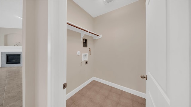 12610 Baldwin Springs Ct, Tomball, TX 77377 - laundry area featuring hookup for an electric dryer, washer hookup, and a glass covered fireplace