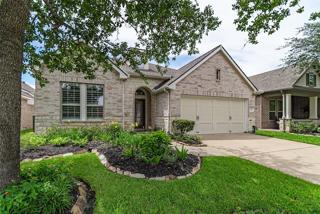 12610 Baldwin Springs Ct, Tomball, TX 77377 - view of front of home with driveway, a garage, stone siding, a front lawn, and a shingled roof