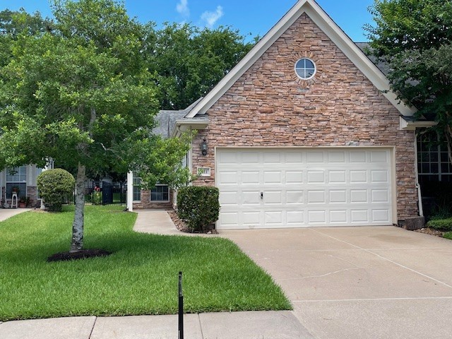 2111 Ridge Wood Ln, Sugar Land, TX 77479 - view of front of property featuring stone siding, concrete driveway, a front lawn, and an attached garage
