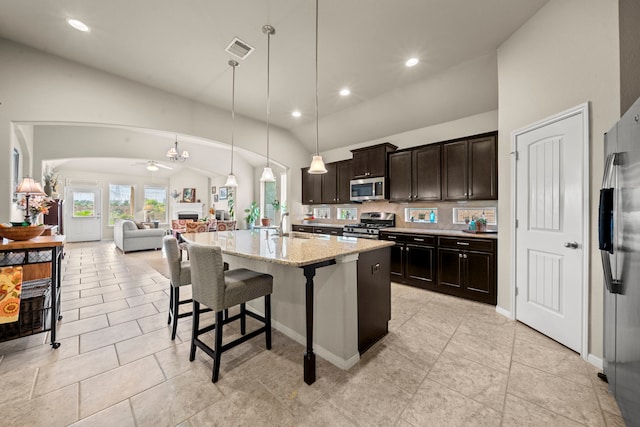 22607 Ebbets Field Dr, Spring, TX 77389 - kitchen with appliances with stainless steel finishes, open floor plan, vaulted ceiling, light stone counters, and a breakfast bar