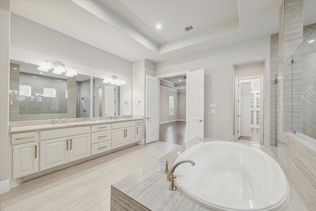 3954 Kelley Pond Dr, Spring, TX 77386 - full bathroom with double vanity, a shower stall, a bath, a tray ceiling, and recessed lighting