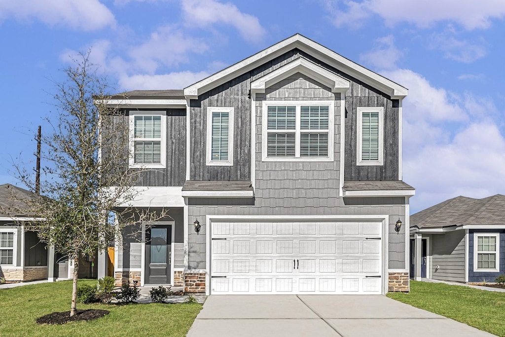8202 Blooming Meadow Dr, Houston, TX 77016 - view of front of property featuring a garage, driveway, stone siding, and a front lawn