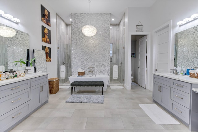 4821 1st St, Houston, TX 77504 - full bath with two vanities, a shower stall, a freestanding tub, recessed lighting, and tile patterned flooring