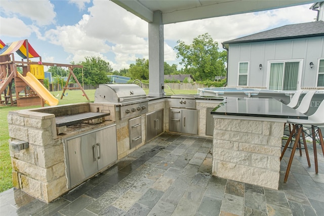 4821 1st St, Houston, TX 77504 - view of patio with exterior kitchen and a playground