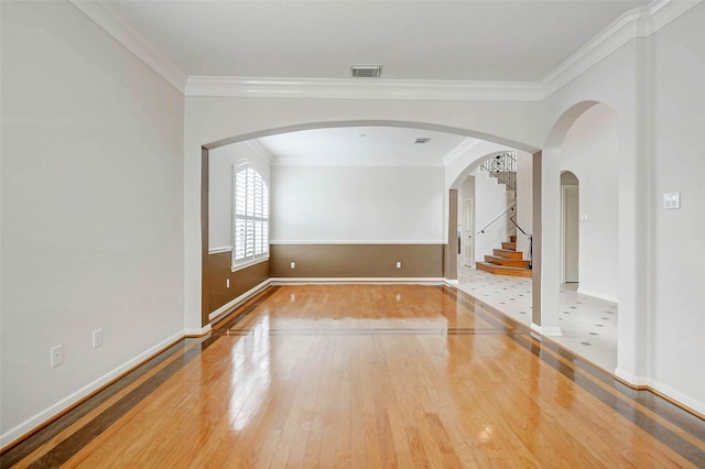 13212 Lismore Pt, Cypress, TX 77429 - empty room with hardwood / wood-style floors, ornamental molding, arched walkways, and stairs