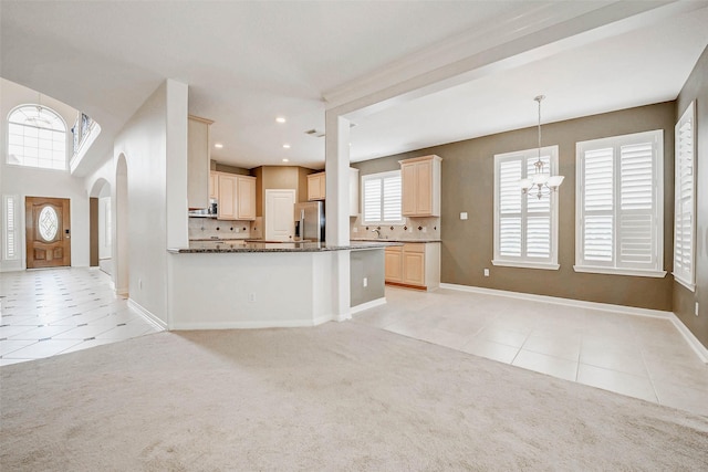 13212 Lismore Pt, Cypress, TX 77429 - kitchen with stainless steel refrigerator with ice dispenser, light tile patterned flooring, light colored carpet, arched walkways, and recessed lighting