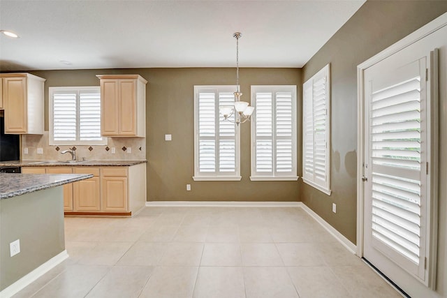 13212 Lismore Pt, Cypress, TX 77429 - kitchen with light brown cabinets, a chandelier, decorative backsplash, light stone counters, and light tile patterned floors