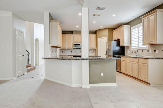 13212 Lismore Pt, Cypress, TX 77429 - kitchen with stainless steel appliances, light brown cabinets, dark stone counters, decorative backsplash, and recessed lighting