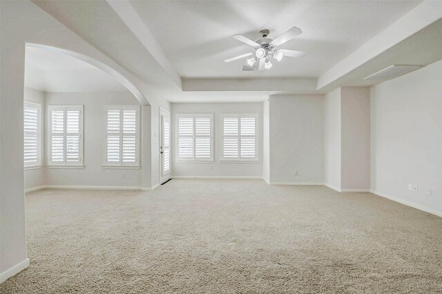 13212 Lismore Pt, Cypress, TX 77429 - carpeted empty room featuring a tray ceiling, a ceiling fan, and arched walkways