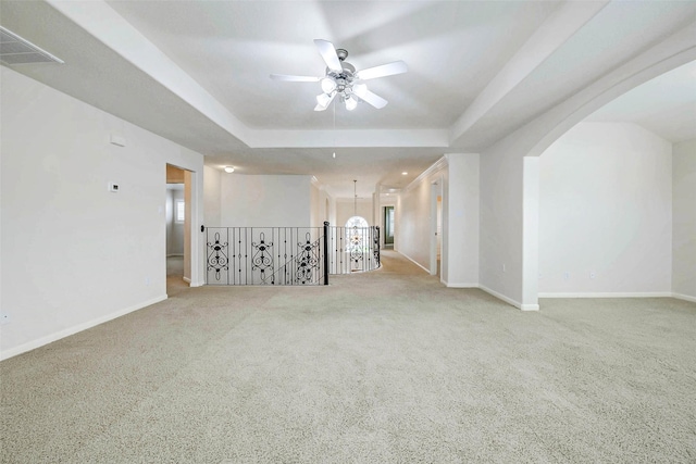 13212 Lismore Pt, Cypress, TX 77429 - carpeted empty room featuring ceiling fan, a tray ceiling, and arched walkways