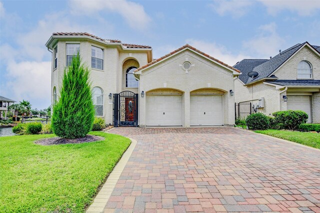 13212 Lismore Pt, Cypress, TX 77429 - mediterranean / spanish house with decorative driveway, a garage, a gate, a front lawn, and a tiled roof