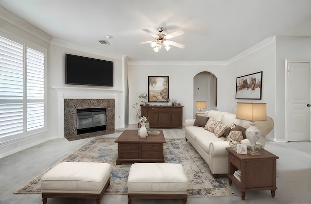 13212 Lismore Pt, Cypress, TX 77429 - living room with arched walkways, ceiling fan, ornamental molding, a fireplace with flush hearth, and plenty of natural light