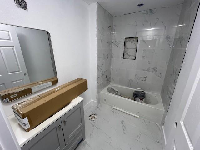 6985 Ellen Ln, Beaumont, TX 77708 - bathroom featuring marble look tile flooring, vanity, and bathtub / shower combination