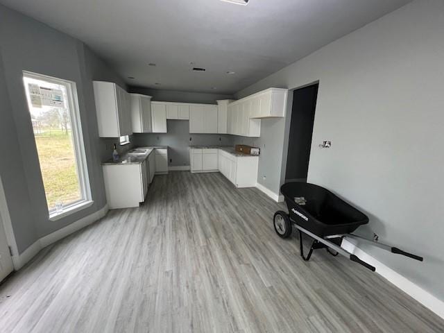 6985 Ellen Ln, Beaumont, TX 77708 - kitchen with light wood-type flooring and white cabinetry