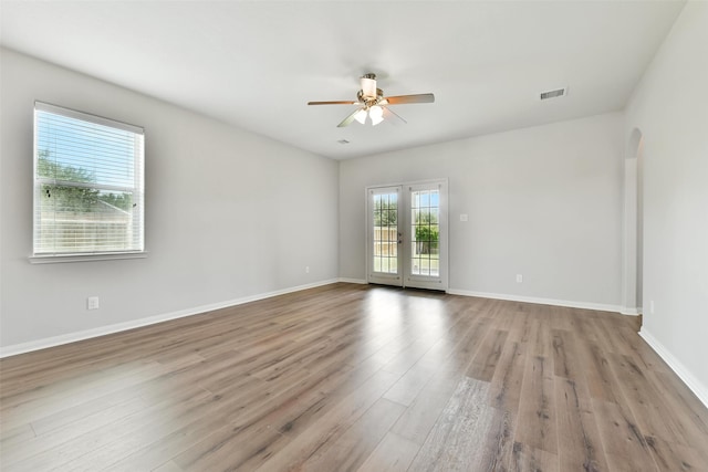 737 Grassy Knoll Ln, La Marque, TX 77568 - spare room featuring ceiling fan, wood finished floors, arched walkways, and french doors