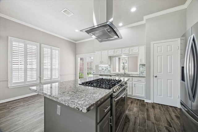 15814 Hillside Falls Trl, Houston, TX 77062 - kitchen with island exhaust hood, appliances with stainless steel finishes, white cabinetry, dark wood-style floors, and recessed lighting