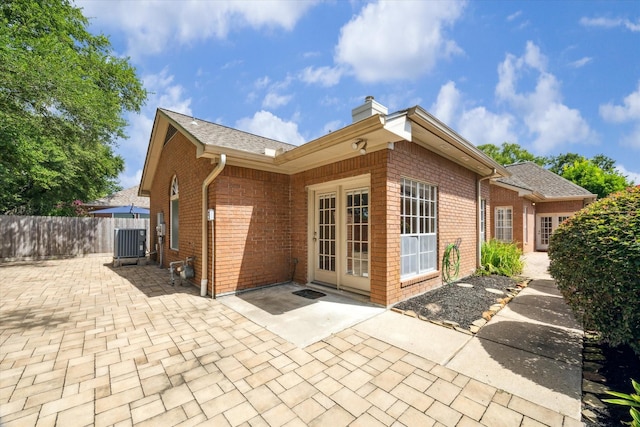 15814 Hillside Falls Trl, Houston, TX 77062 - rear view of house featuring a patio, brick siding, and a chimney
