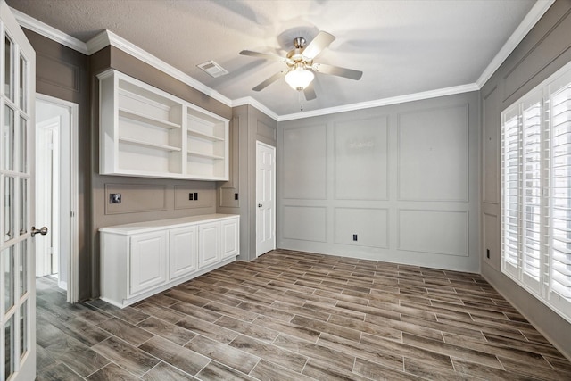 15814 Hillside Falls Trl, Houston, TX 77062 - spare room featuring a decorative wall, dark wood-style flooring, a ceiling fan, plenty of natural light, and ornamental molding