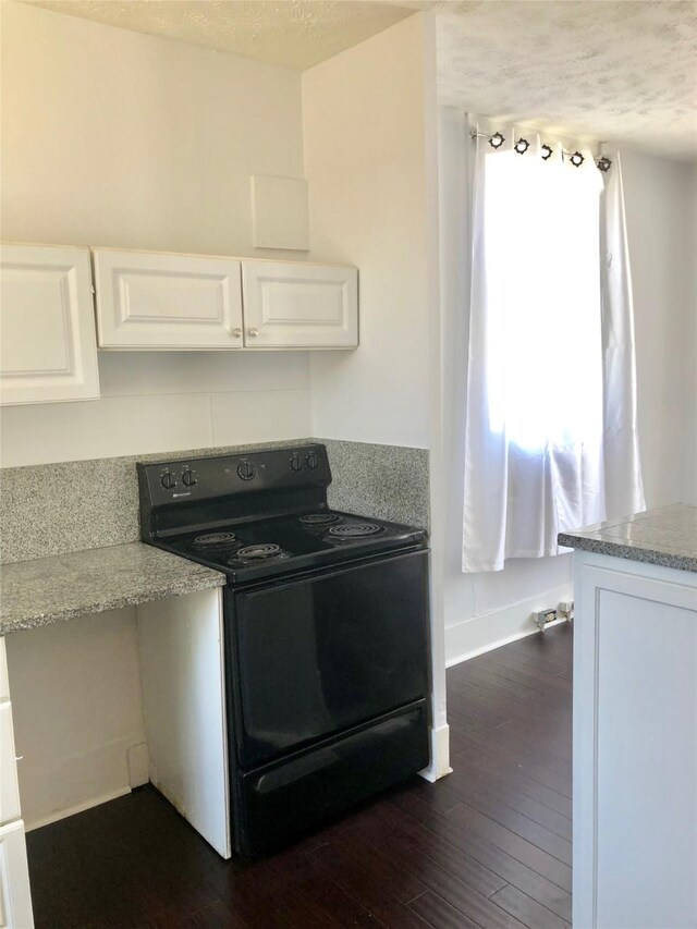 915 11th St, Galveston, TX 77550 - kitchen featuring black electric range oven, dark wood-type flooring, white cabinets, a textured ceiling, and light countertops