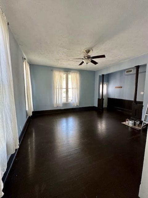 915 11th St, Galveston, TX 77550 - empty room featuring a ceiling fan, a wood stove, and dark wood-style floors