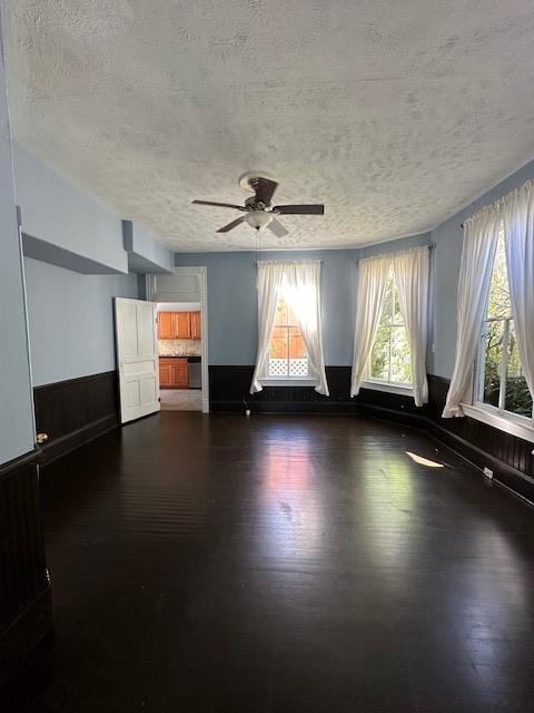 915 11th St, Galveston, TX 77550 - unfurnished room with dark wood-style floors, ceiling fan, and a textured ceiling