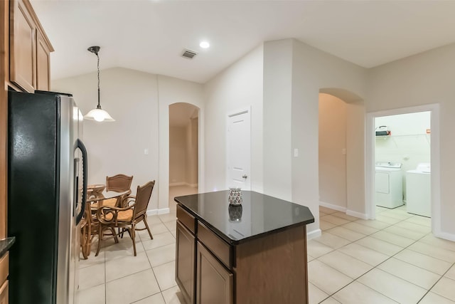 11410 Sandstone Canyon Dr, Humble, TX 77396 - kitchen featuring arched walkways, stainless steel fridge, separate washer and dryer, light tile patterned flooring, and a center island