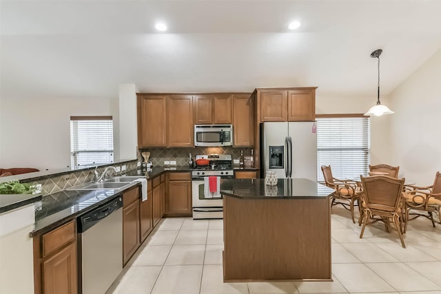 11410 Sandstone Canyon Dr, Humble, TX 77396 - kitchen featuring stainless steel appliances, decorative backsplash, brown cabinets, pendant lighting, and a kitchen island