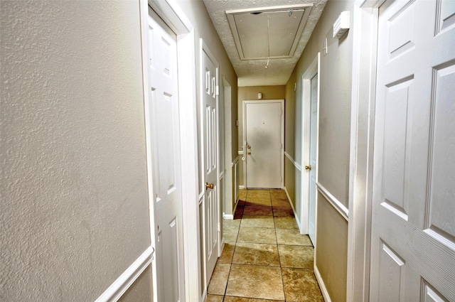7354 Stone Pine Ln, Houston, TX 77041 - hallway with attic access, a textured wall, and light tile patterned floors