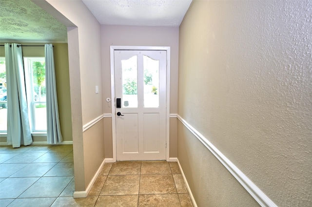 7354 Stone Pine Ln, Houston, TX 77041 - doorway to outside featuring a textured wall, a textured ceiling, and light tile patterned floors