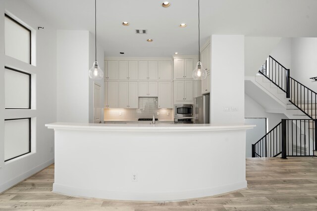 906 Reinerman St, Houston, TX 77007 - kitchen with appliances with stainless steel finishes, recessed lighting, white cabinetry, tasteful backsplash, and light countertops
