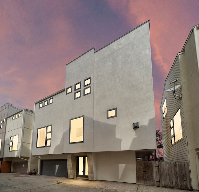 906 Reinerman St, Houston, TX 77007 - property at dusk featuring a garage and concrete driveway