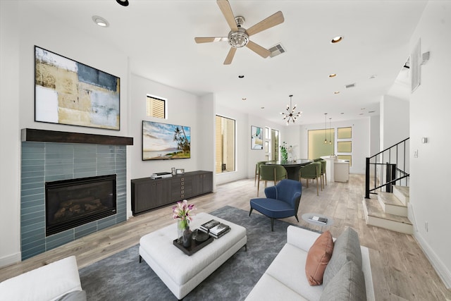 906 Reinerman St, Houston, TX 77007 - living room with stairs, light wood-type flooring, a ceiling fan, a tiled fireplace, and recessed lighting