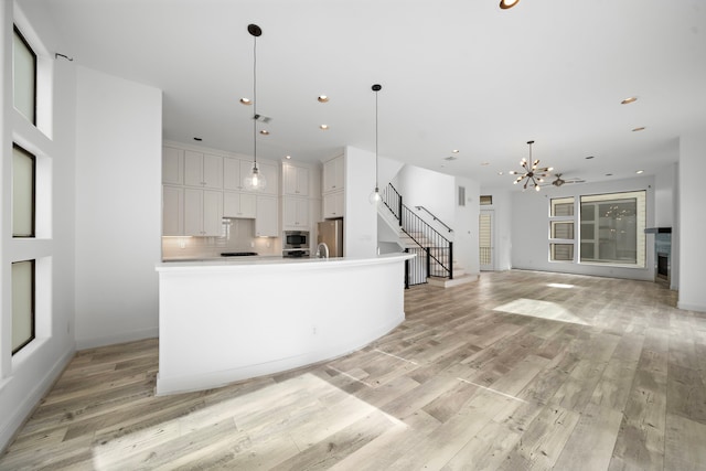 906 Reinerman St, Houston, TX 77007 - kitchen with stainless steel appliances, light wood-type flooring, white cabinets, a chandelier, and recessed lighting