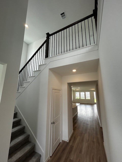 1123 Buffalo Run, Tomball, TX 77375 - stairway featuring a high ceiling, wood finished floors, and recessed lighting