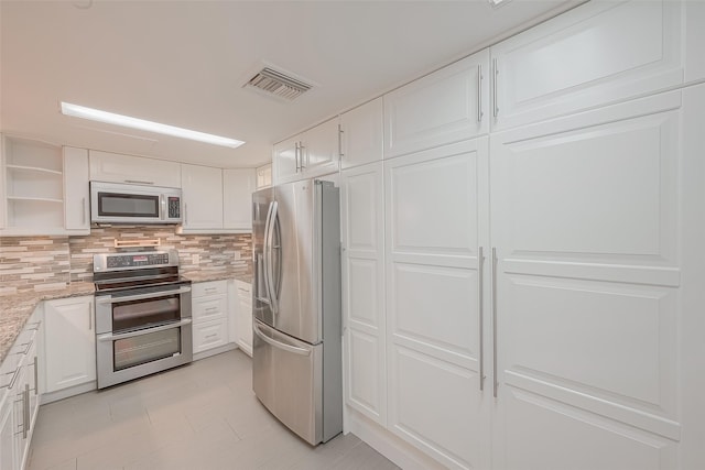 5150 Hidalgo St Unit 204, Houston, TX 77056 - kitchen with stainless steel appliances, white cabinetry, decorative backsplash, and light stone counters